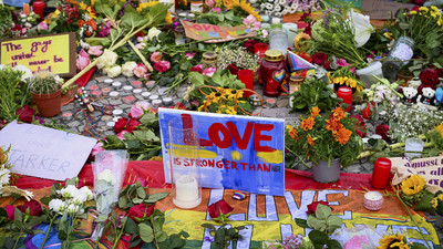 Blumen, Kerzen, Botschaften und eine Regenbogenfahne sind am Morgen auf dem Pariser Platz vor dem Brandenburger Tor zu sehen.