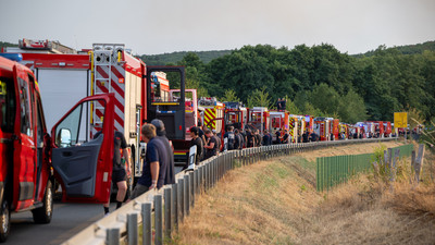 Auf der B399 nahe Hürtgenwald-Gey warten Einsatzkräfte auf die nächste Mission. Die Belastung ist hoch, deshalb müssen die Helfer oft aus dem direkten Brandgebiet ausgewechselt werden.