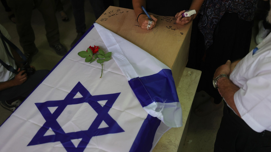 Angehörige und Familienmitglieder schreiben auf den Sarg während der Beerdigung der israelisch-deutschen Geisel Shani Louk in Moshav Srigim nahe der Stadt Beit Shemesh. (Foto: EPA/ABIR SULTAN)